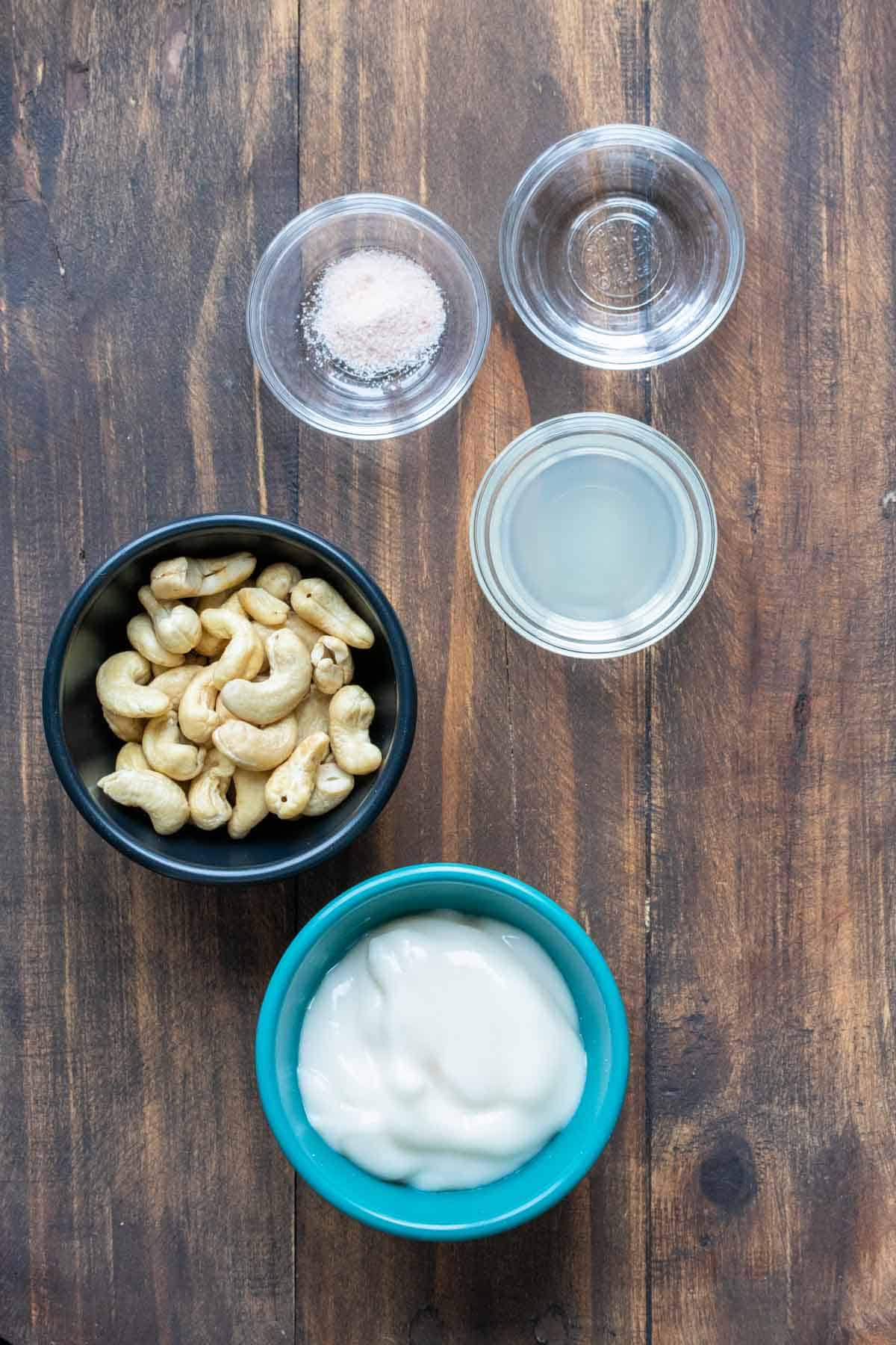 Bowls filled with cashews, plain yogurt, lemon juice, salt and vinegar