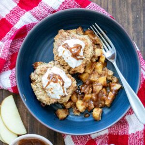 Blue bowl with two pieces of apple cobbler and whipped cream