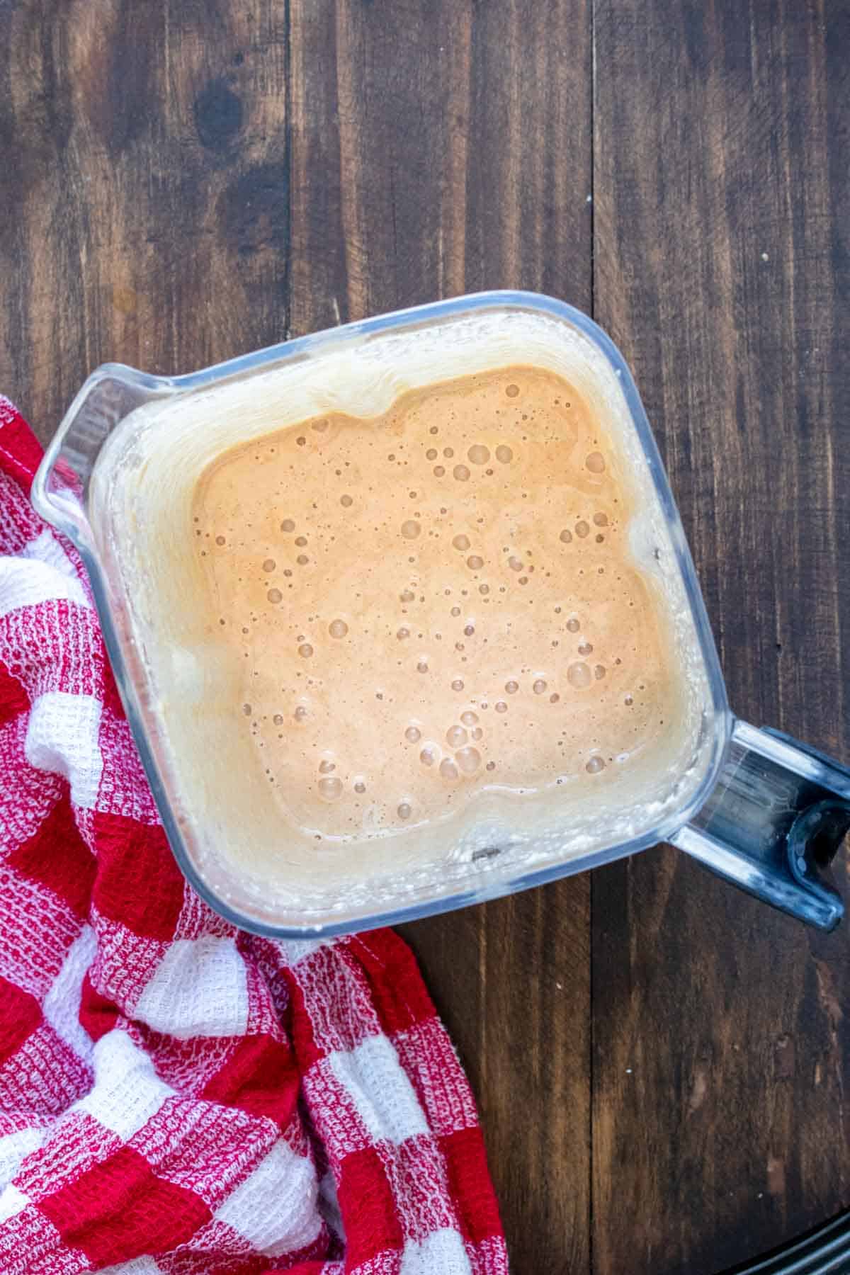 Top view of a blender with a cream smoothie in it