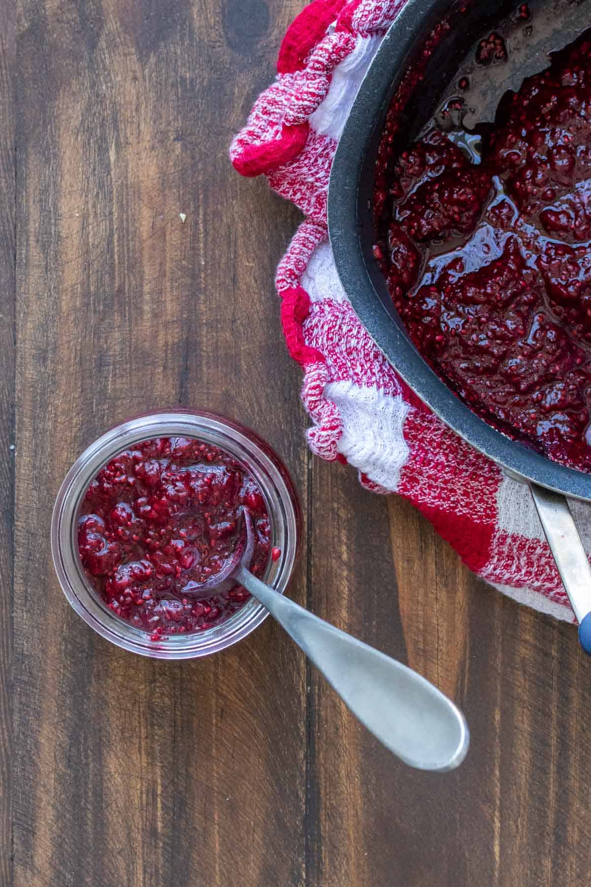 Top view of a glass jar with jam in it and a spoon