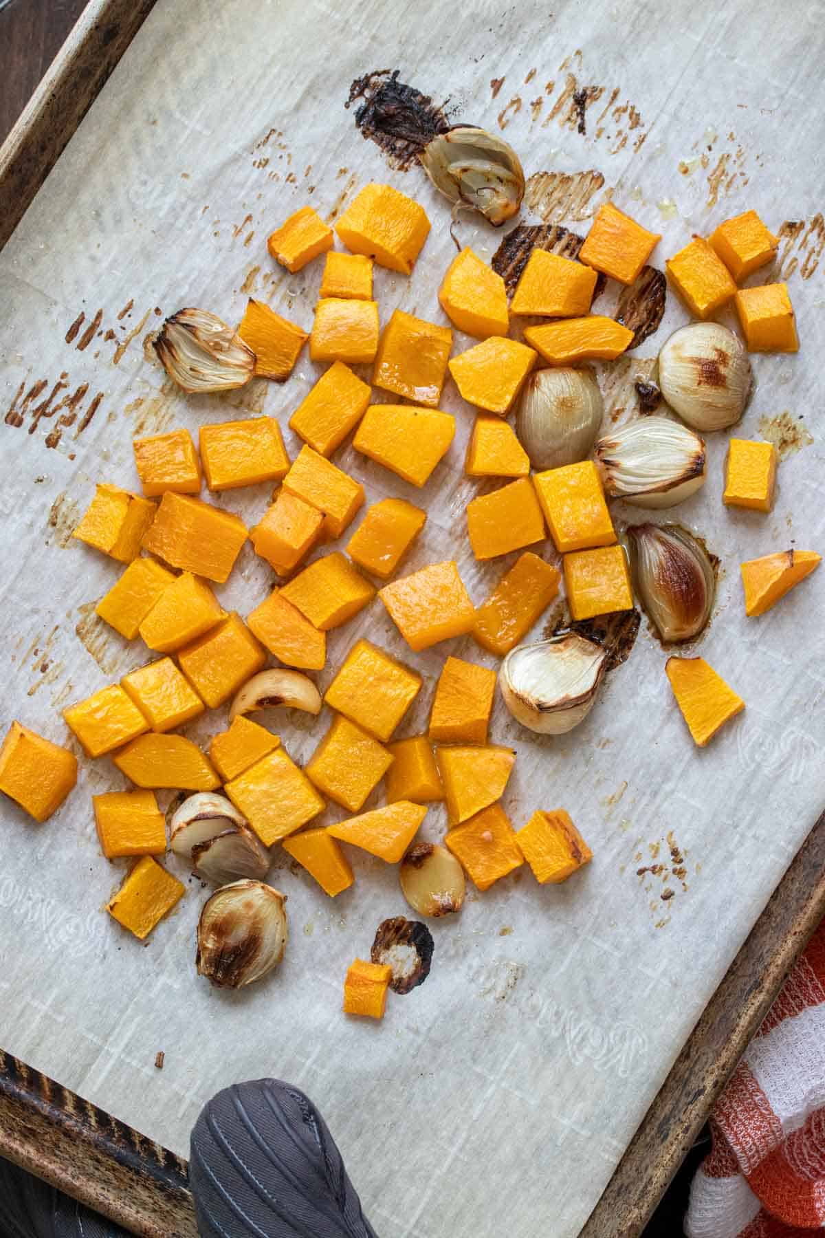 Top view of roasted butternut squash, shallots and garlic