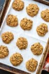 Parchment lined cookie sheet with baked chocolate chip pumpkin cookies on it