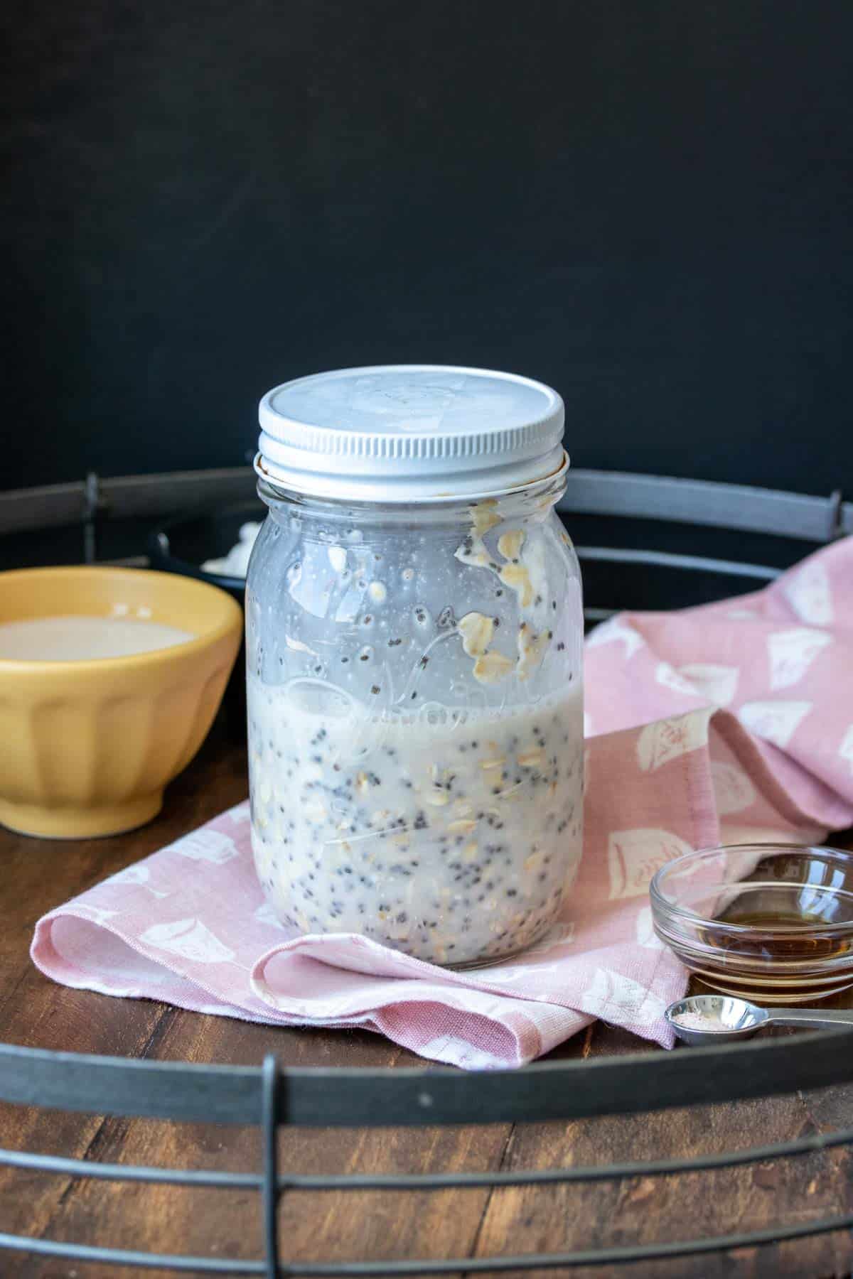 Glass jar filled half way with a milk, oat and chia seed mixture