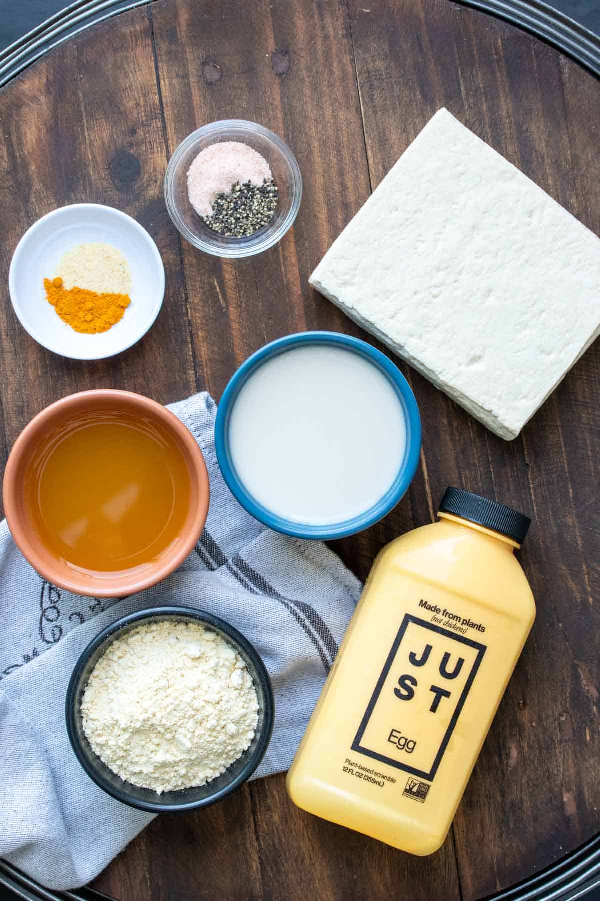 Bowls with spices, broth, milk, flour a block of tofu and yellow container