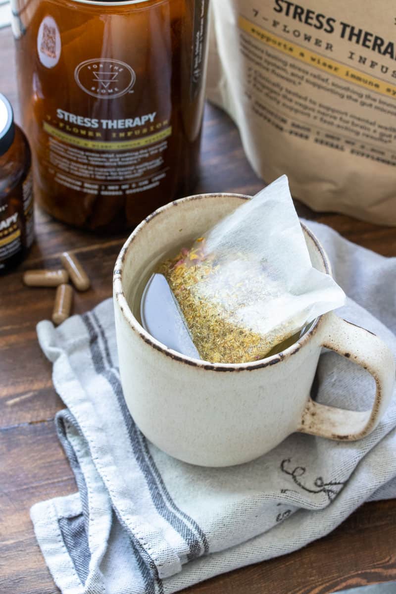 Creme mug with a tea bag in water on a cream striped towel