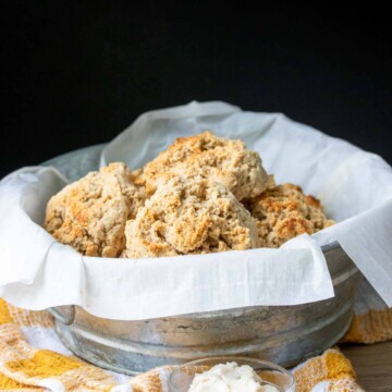 Metal bowl with parchment paper and golden biscuits piled inside