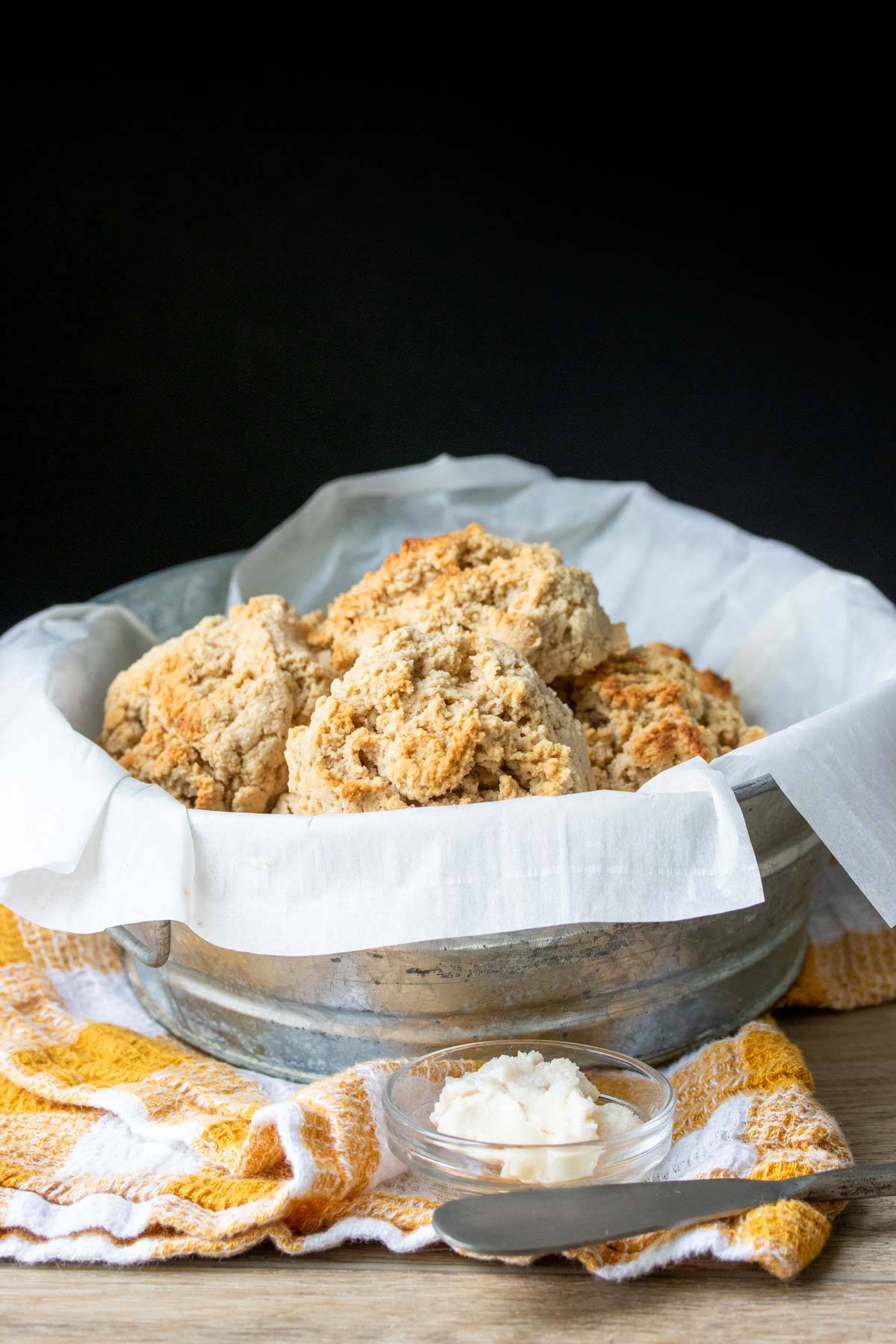 Metal bowl with parchment paper and golden biscuits piled inside