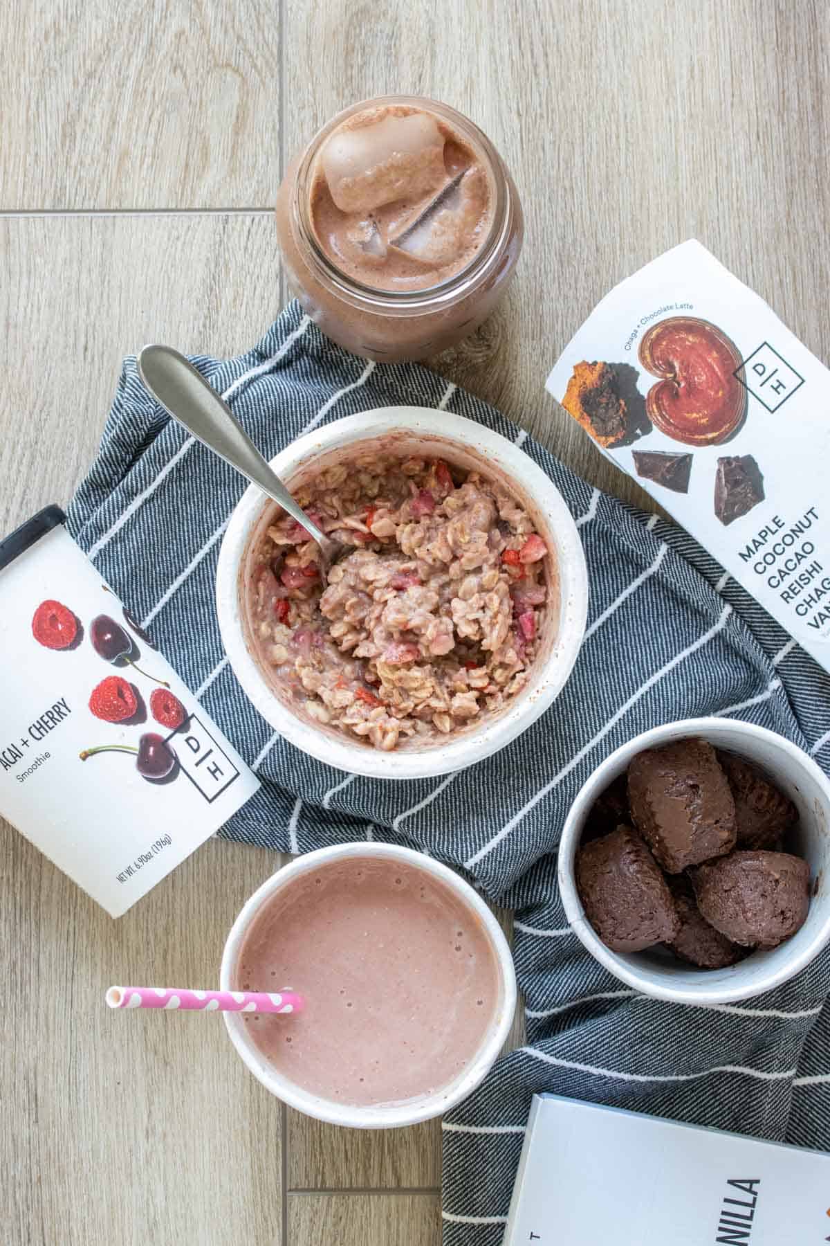 Top view of a bowl of oats surrounded by drinks and chocolate protein balls