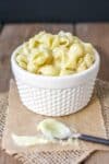 White texture bowl with pasta shells mixed with a white cheesy sauce