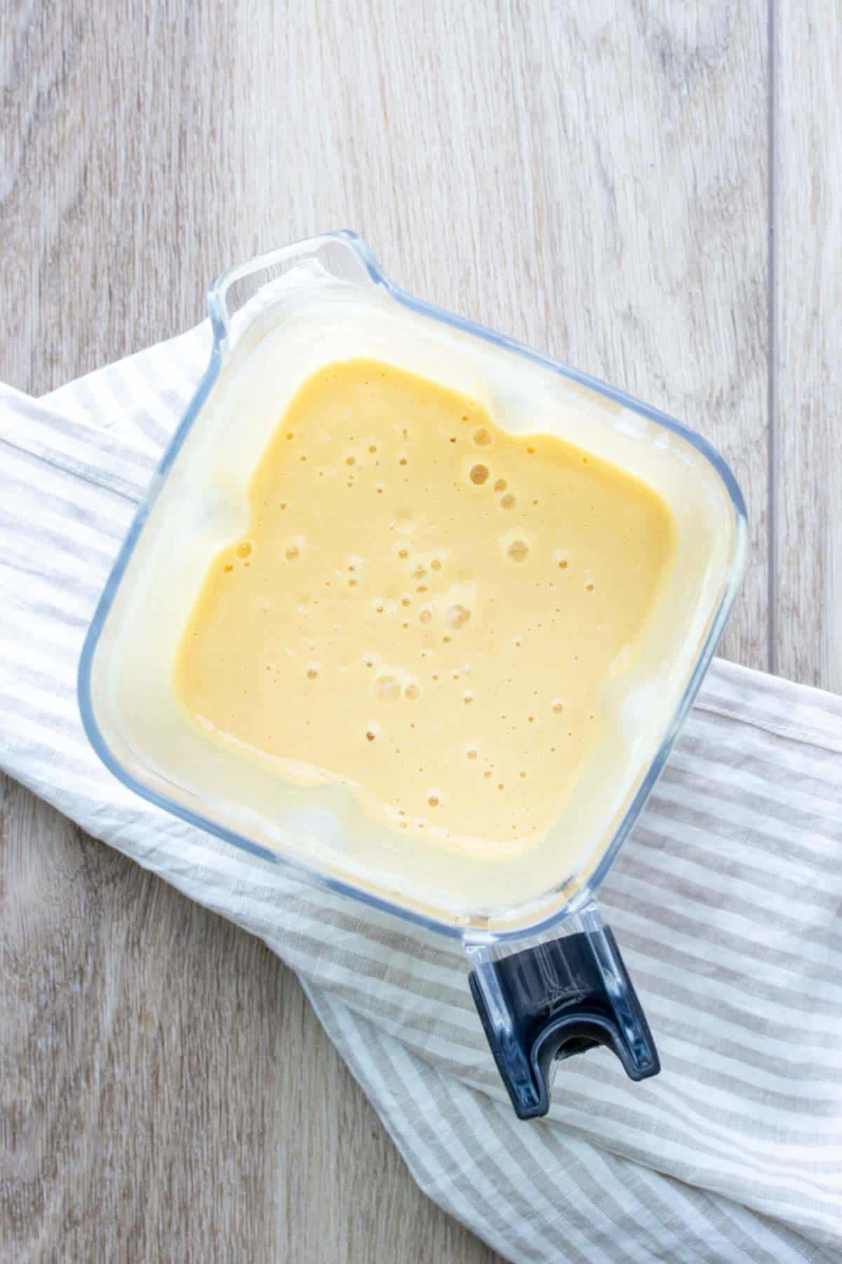 Top view of a blender with a rich cream colored sauce inside