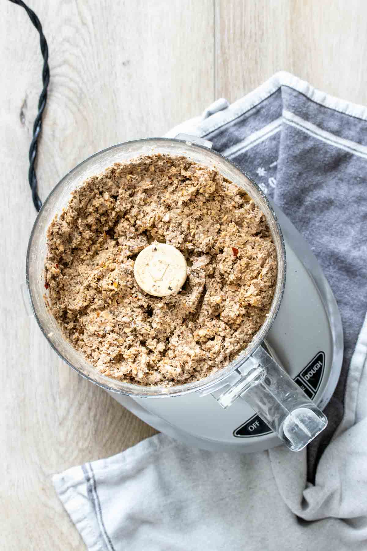 Top view of a food processor with a blended bean based mixture in it