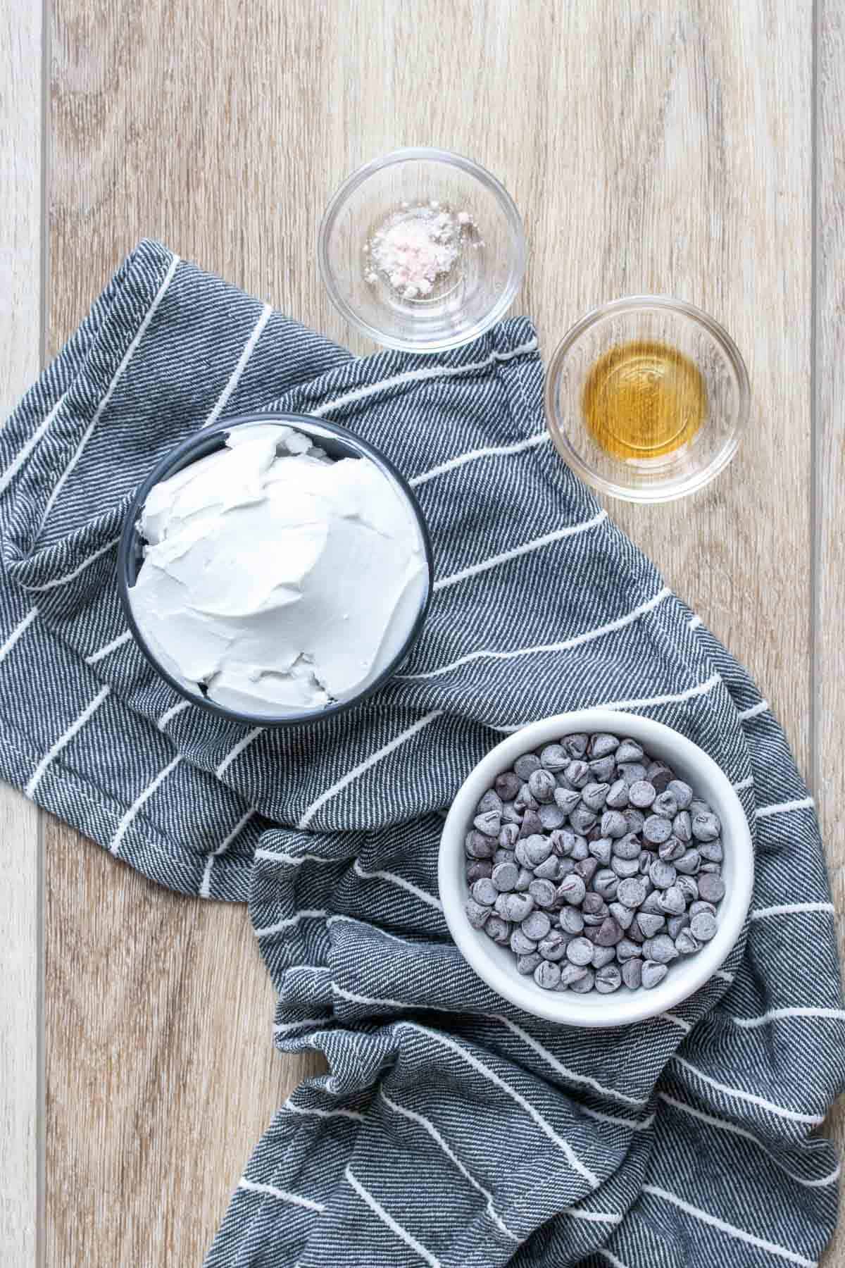 Bowls of coconut cream, chocolate chips, salt and vanilla