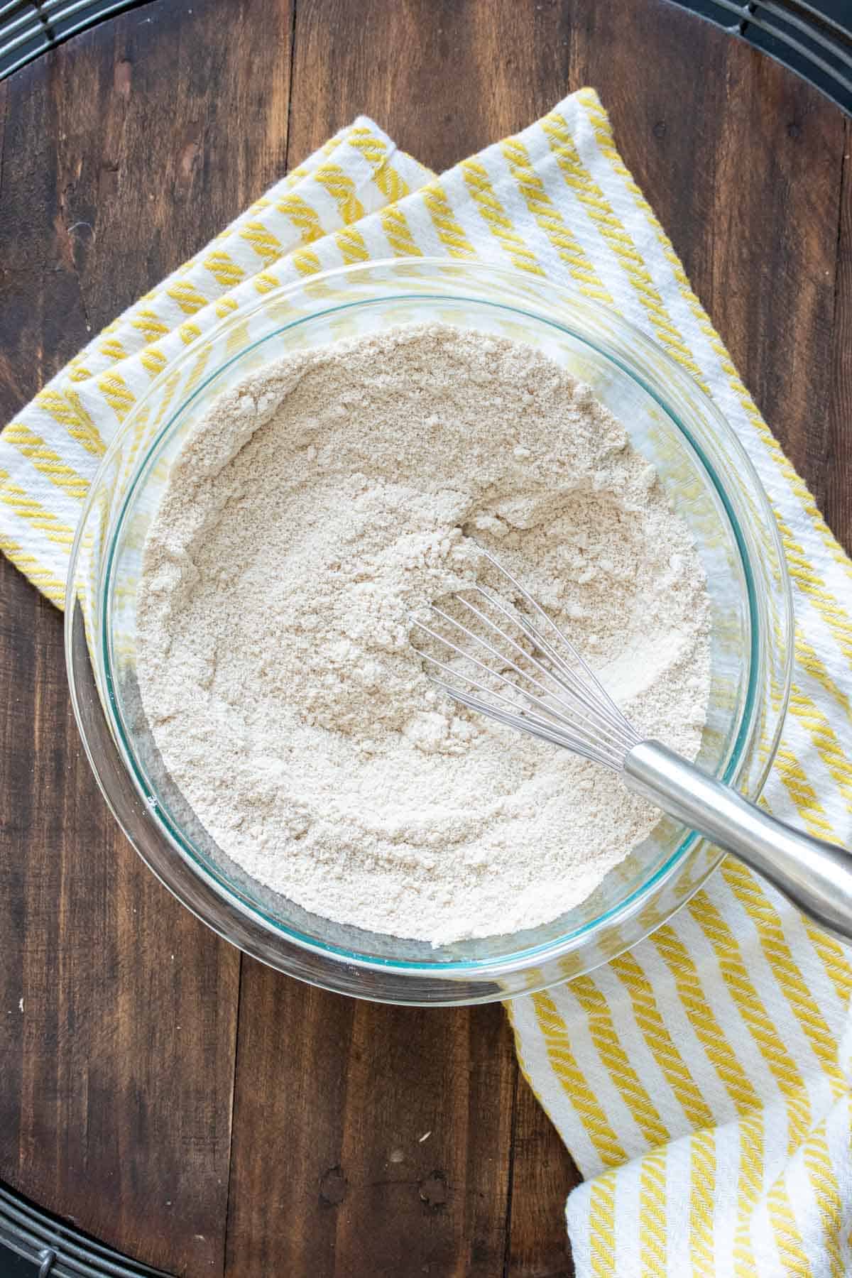 Flour mixture in a glass bowl with a whisk