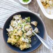 Top view of a dark blue bowl filled with a creamy pasta and broccoli mix