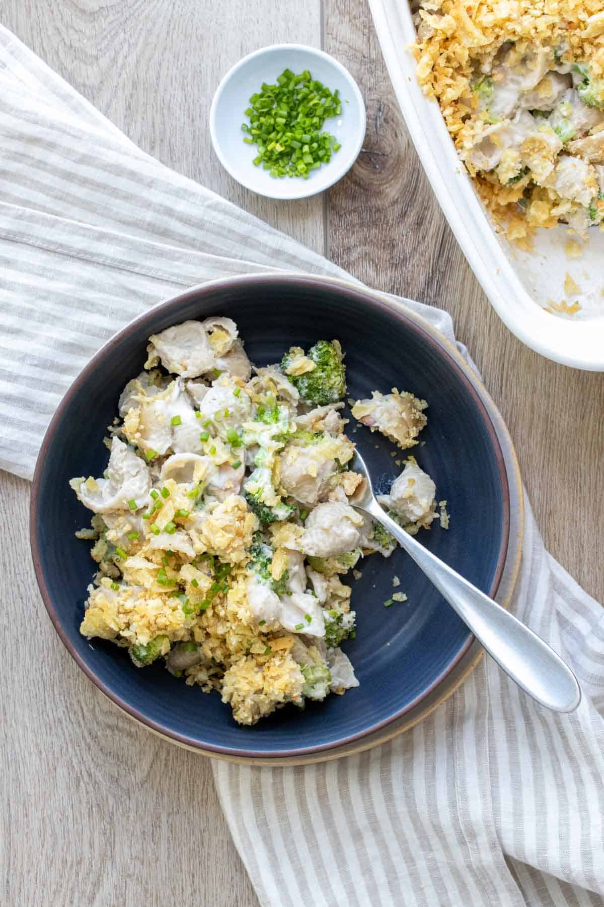 Top view of a dark blue bowl filled with a creamy pasta and broccoli mix