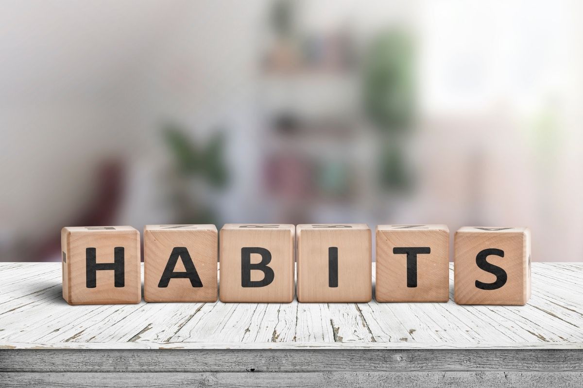 Brown blocks sitting on a white surface spelling out the work habit