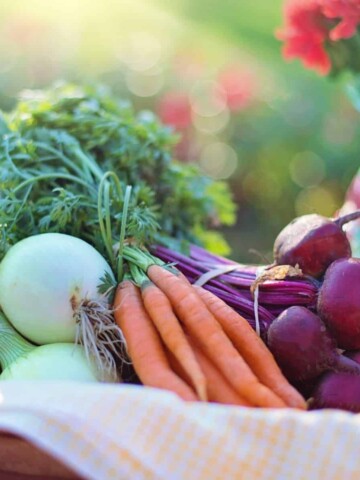 Basket with a while towel filled with fresh picked vegetables