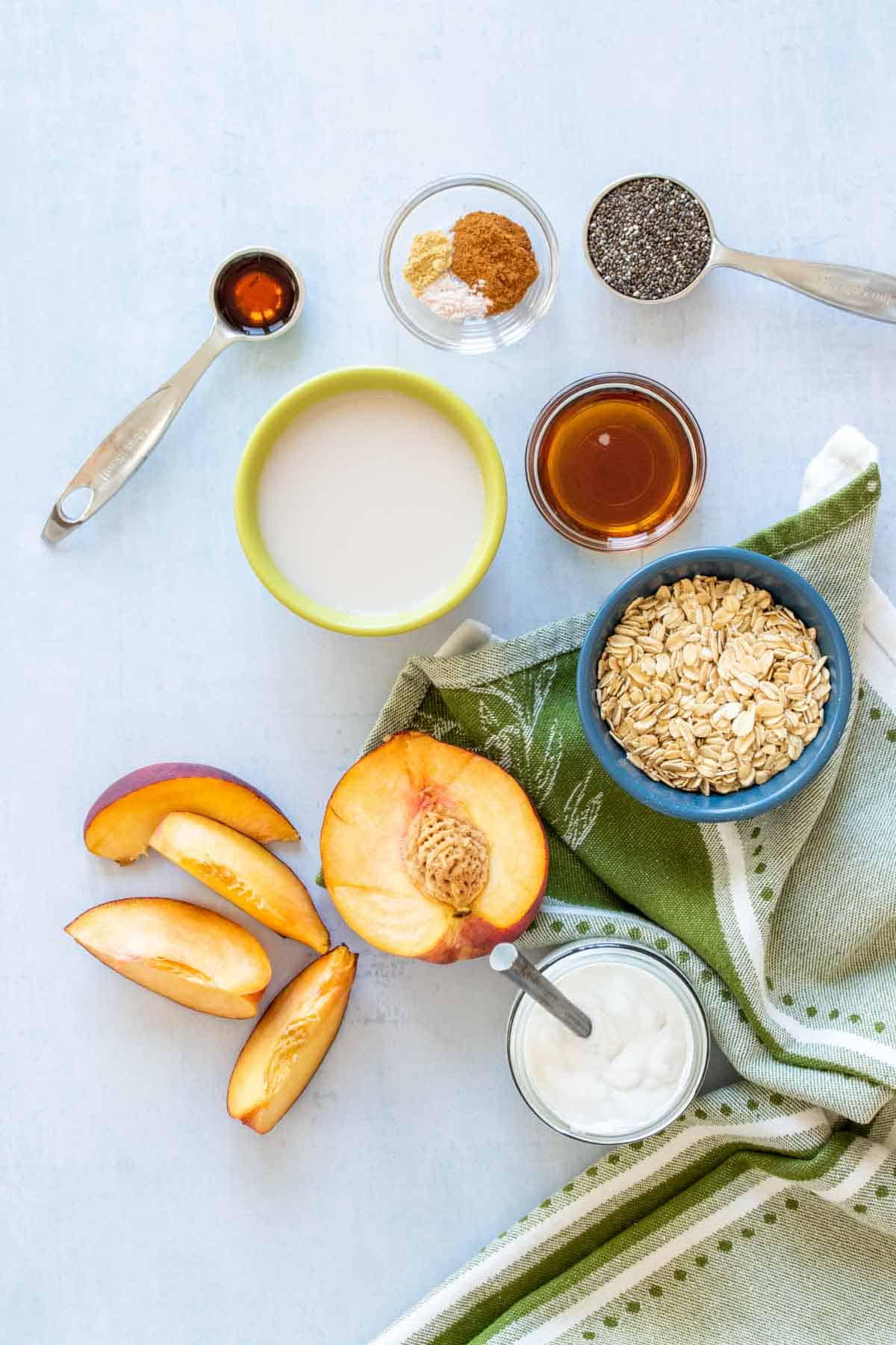 Top view of peaches, oats, milk and other ingredients for making overnight oats