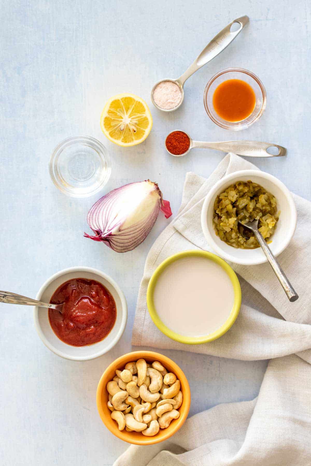 Top view of ingredients needed to make a dairy free cashew based thousand island dressing sitting on a light surface