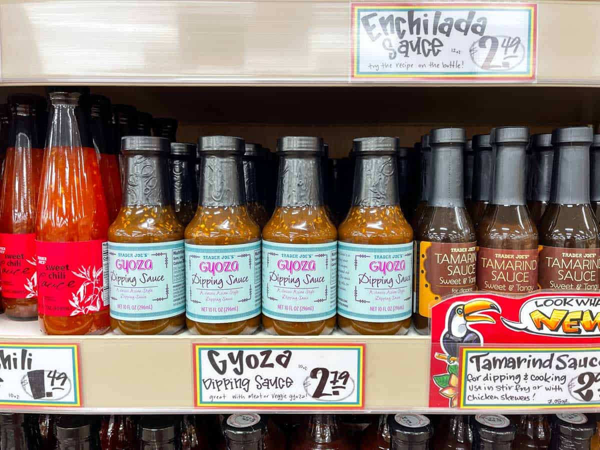 A grocery store shelf with Asian style sauces lined up