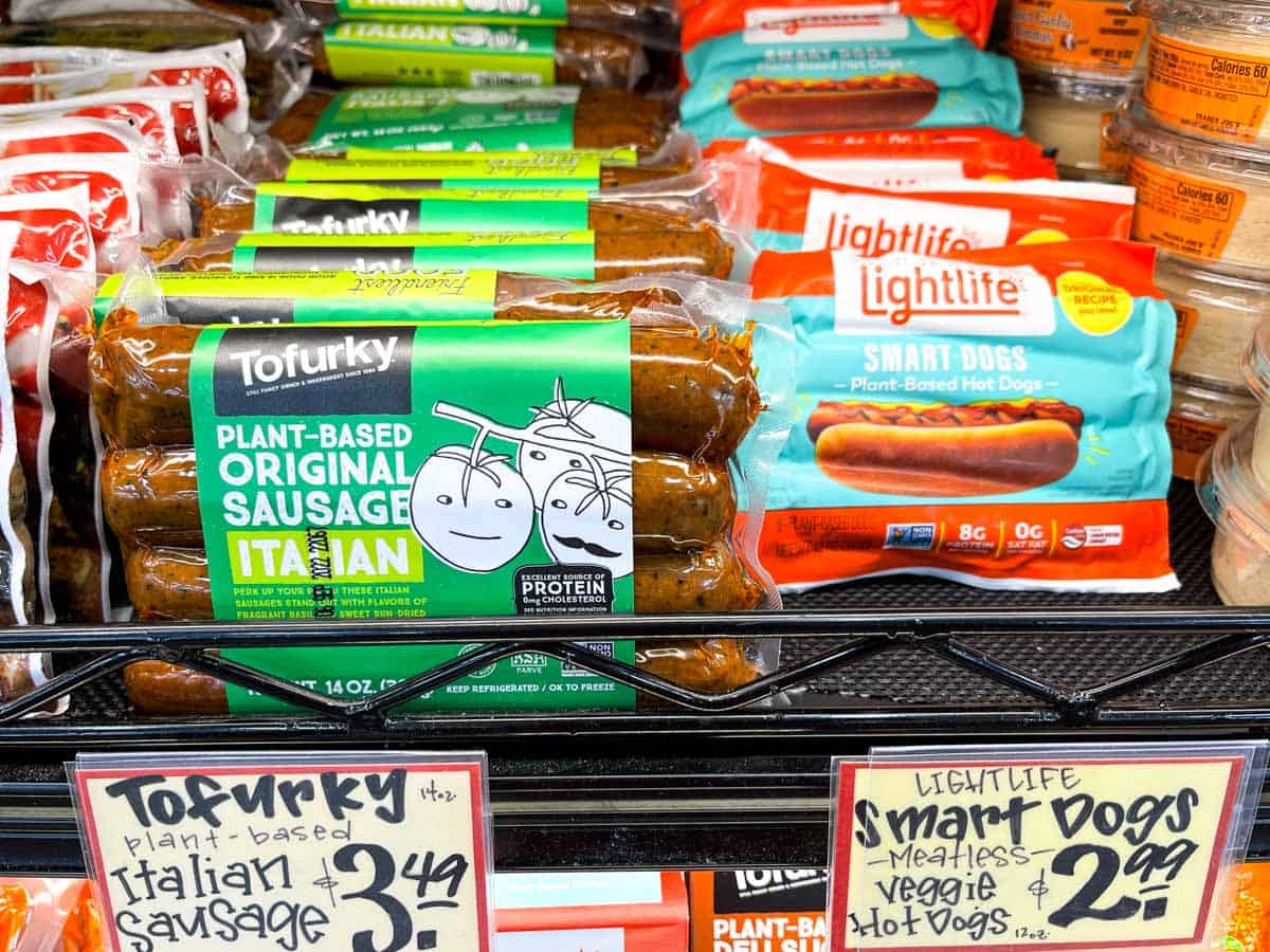 Different meat free sausages and hot dogs on a shelf in a grocery store