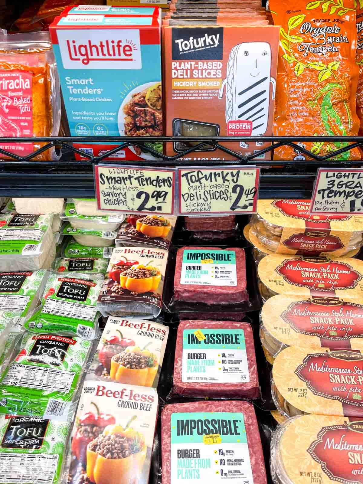 A selection of meal alternative products next to tofu on a grocery store shelf