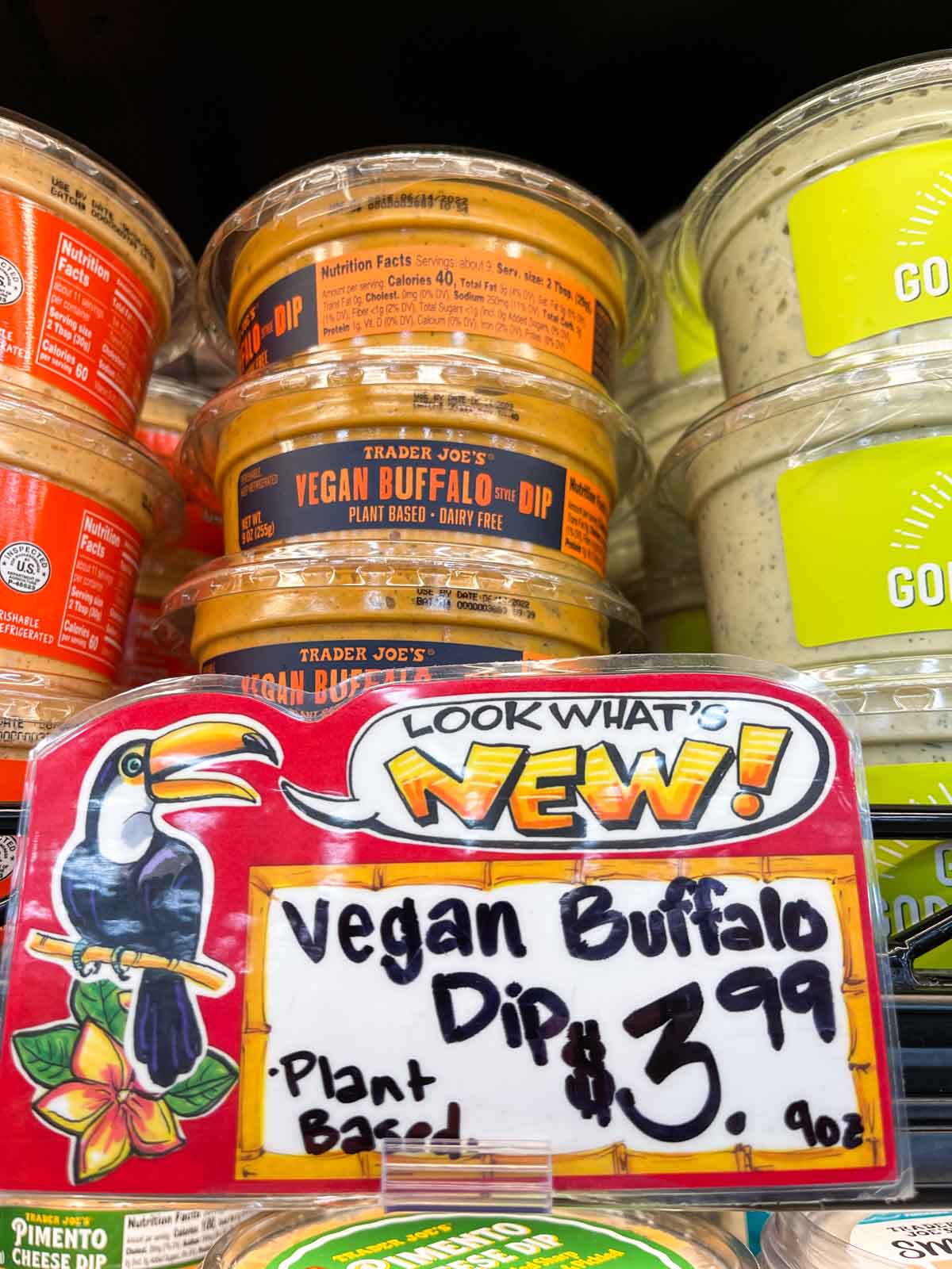 A stack of vegan buffalo dip on a shelf at a grocery store