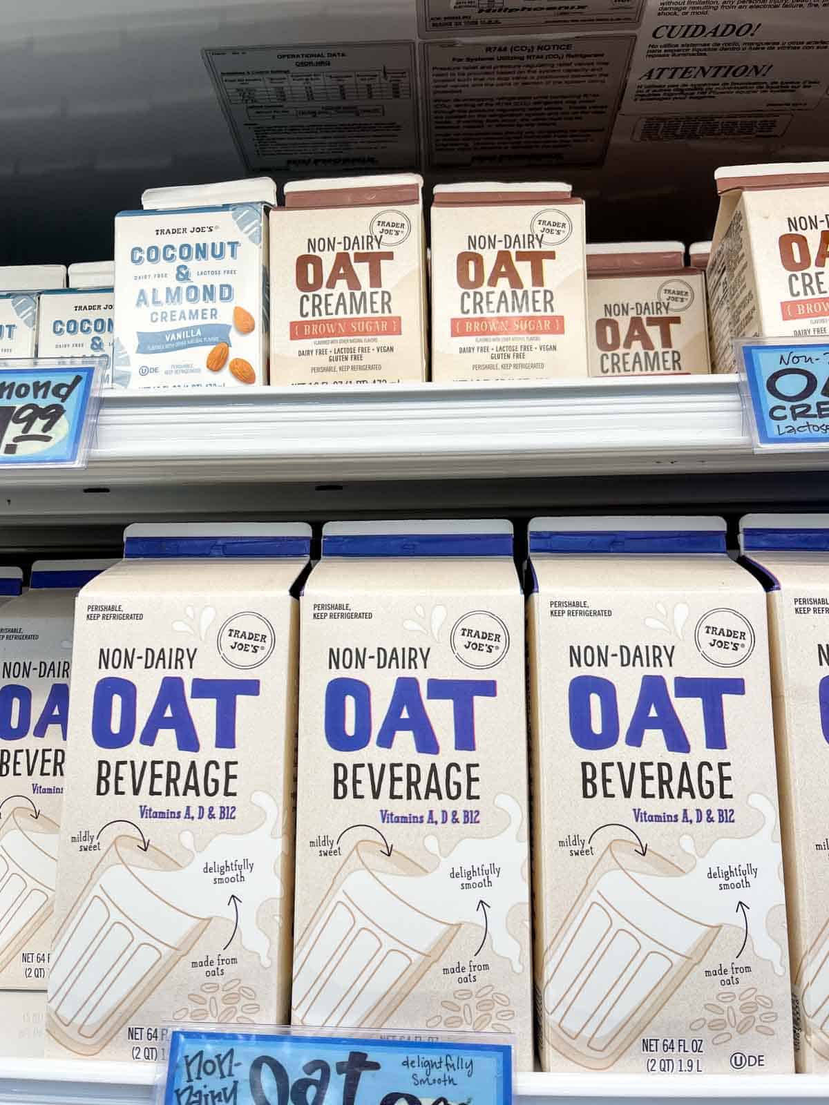Shelves at a grocery store with cartons of oat milk beverages