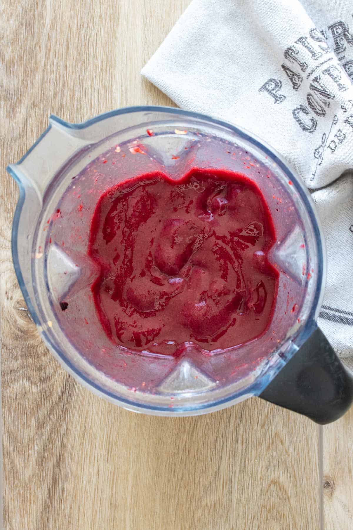 Top view of a blender with a deep purple pink frozen puree inside
