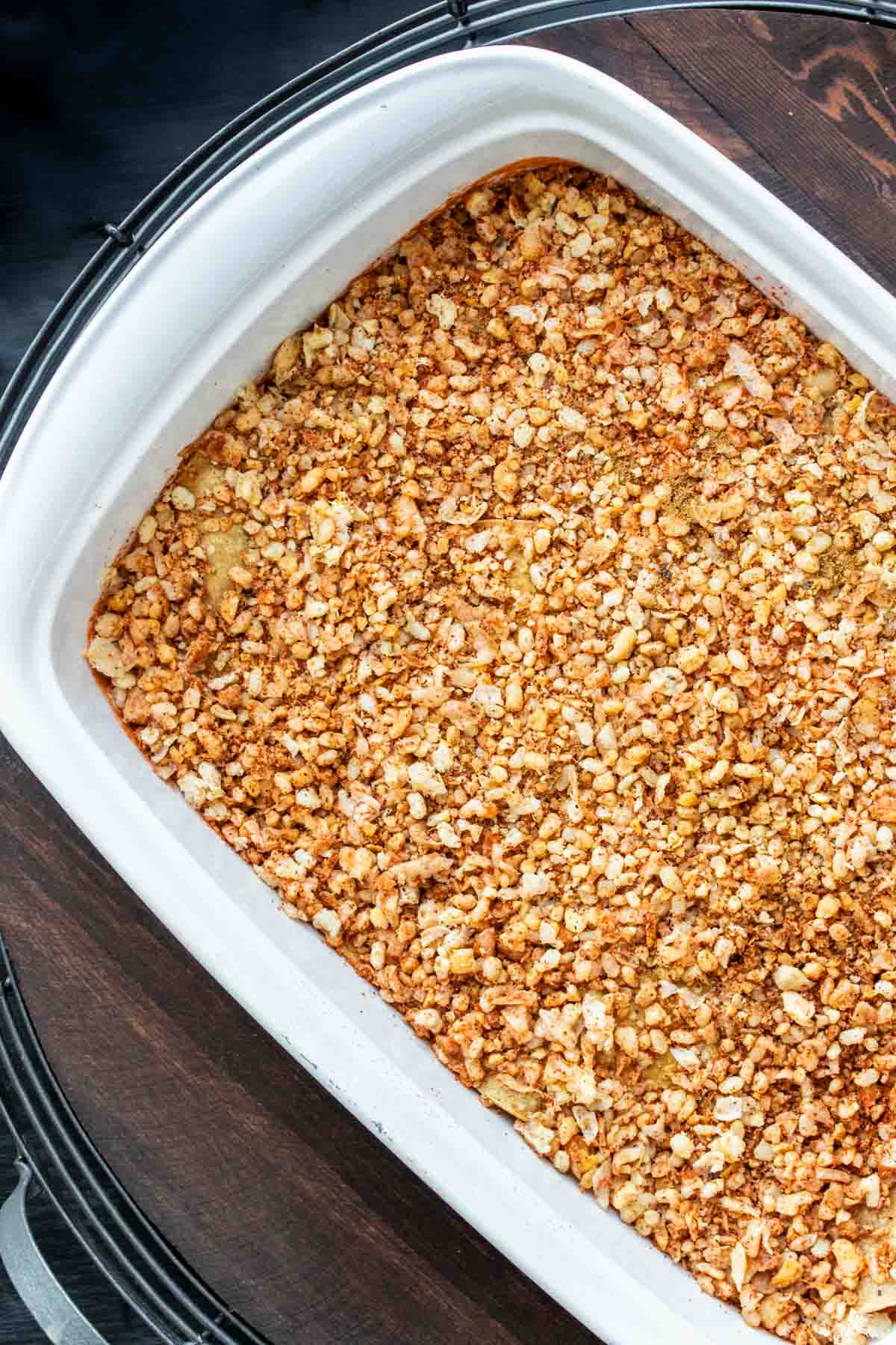 Top view of a white baking dish with an orange meaty crumble in it.