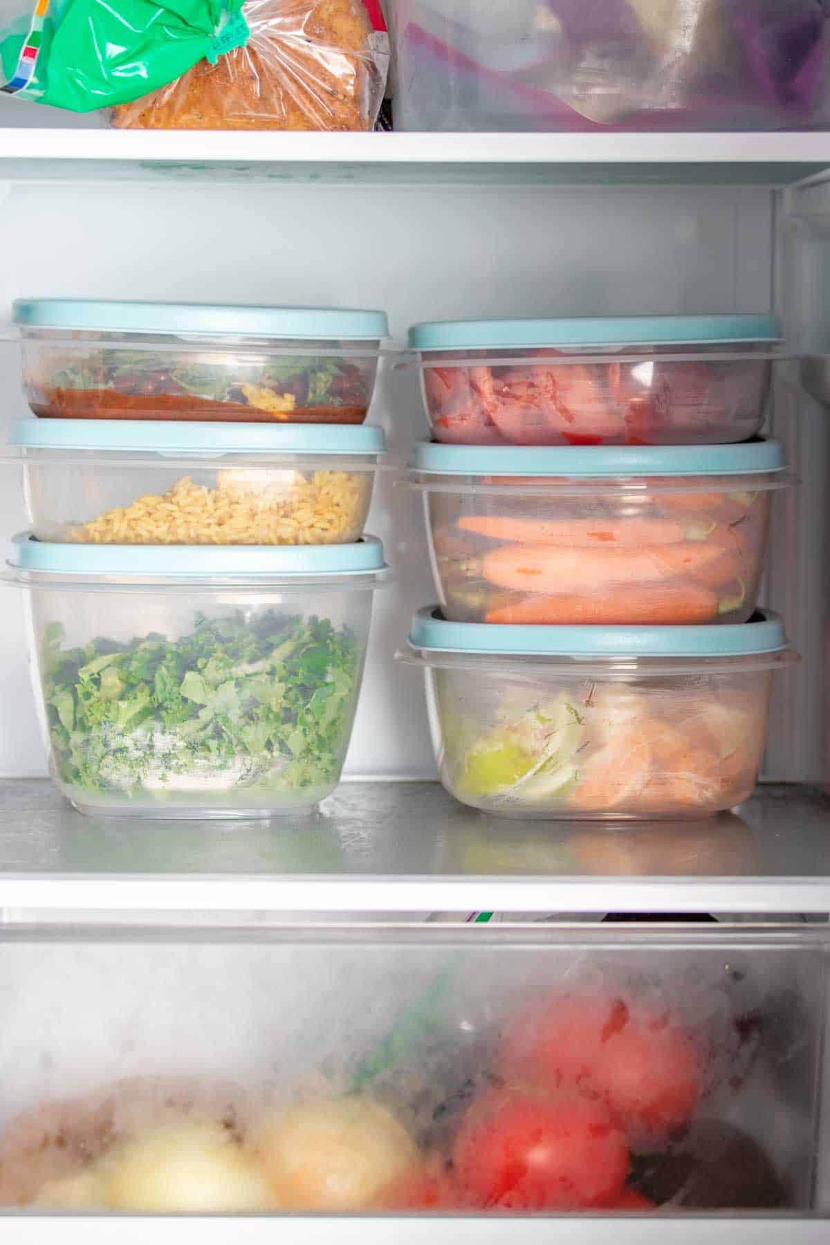 Two stacks of three containers on a shelf in the refrigerator.
