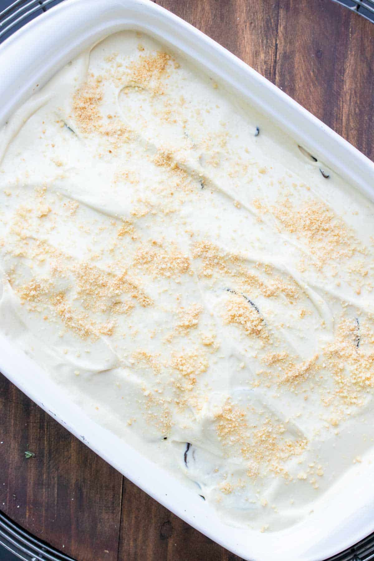 Top view of a creamy mixture on top of a casserole in a white baking dish sprinkled with Parmesan.