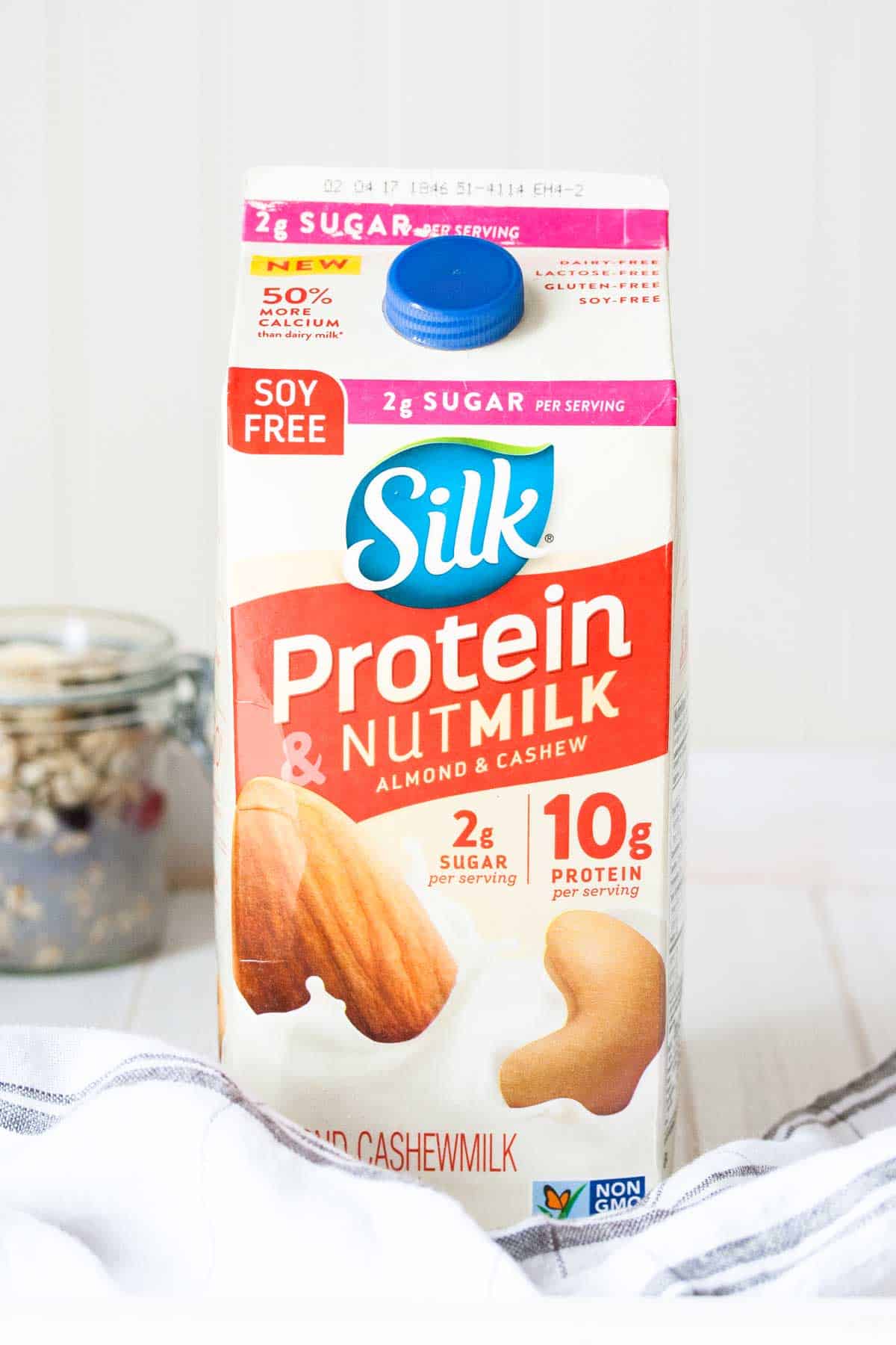 A red and white carton of protein nut milk by Silk on a white surface.