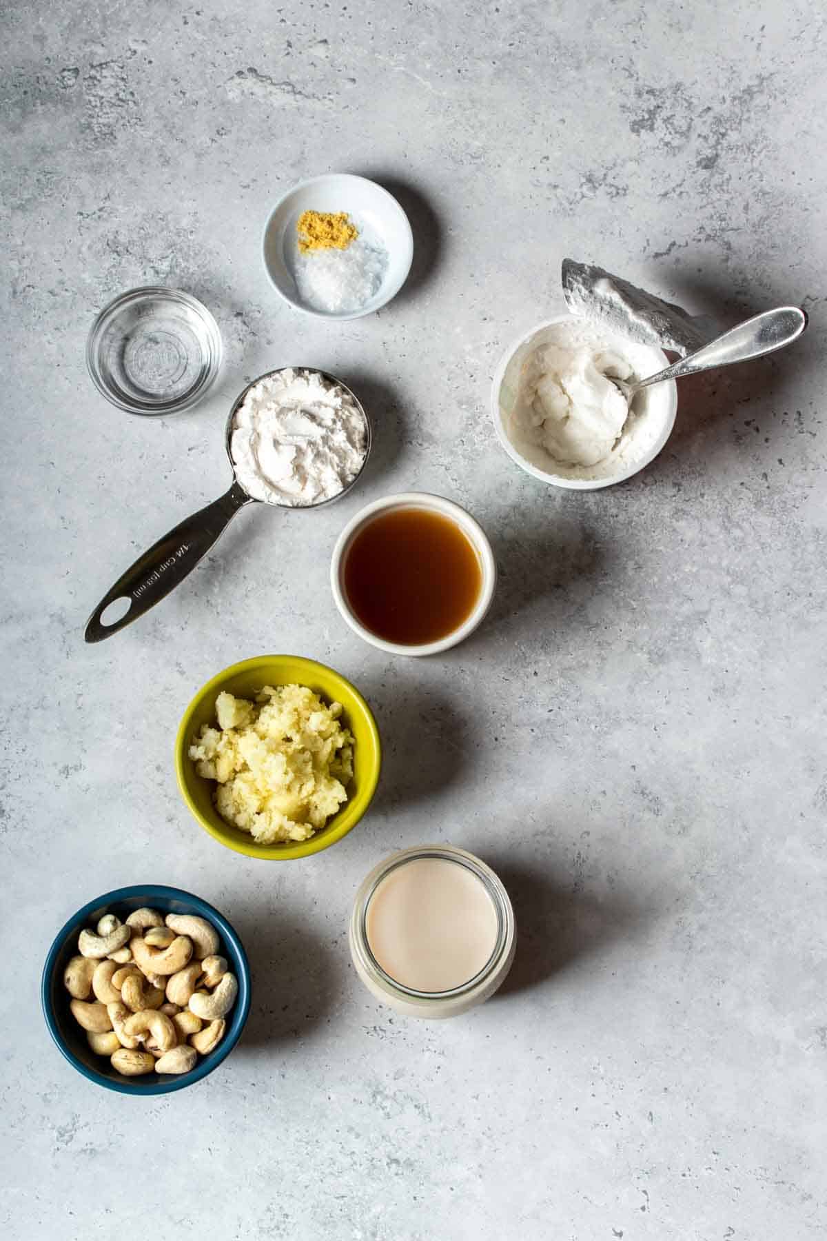 Top view of different bowls with ingredients to make a cashew based cheese.