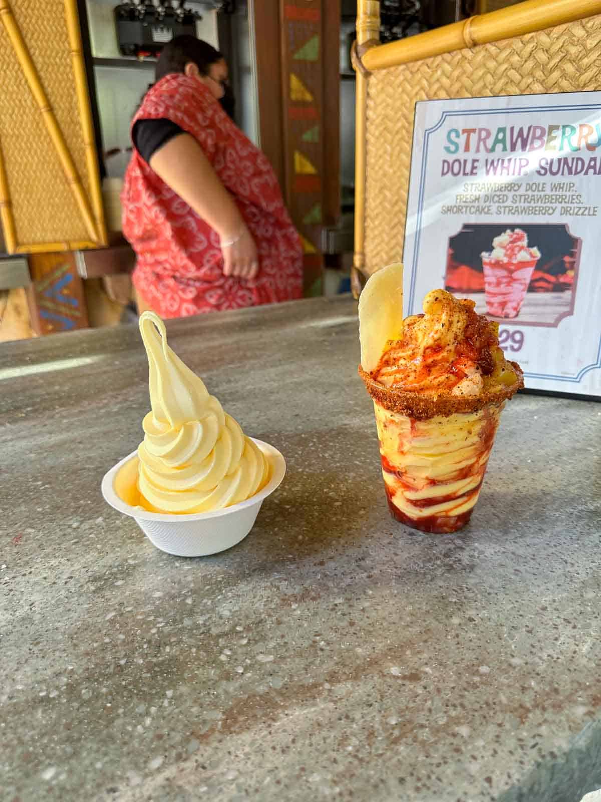 A bowl of pineapple dole whip and one of chile mango flavor on a countertop at Disneyland.