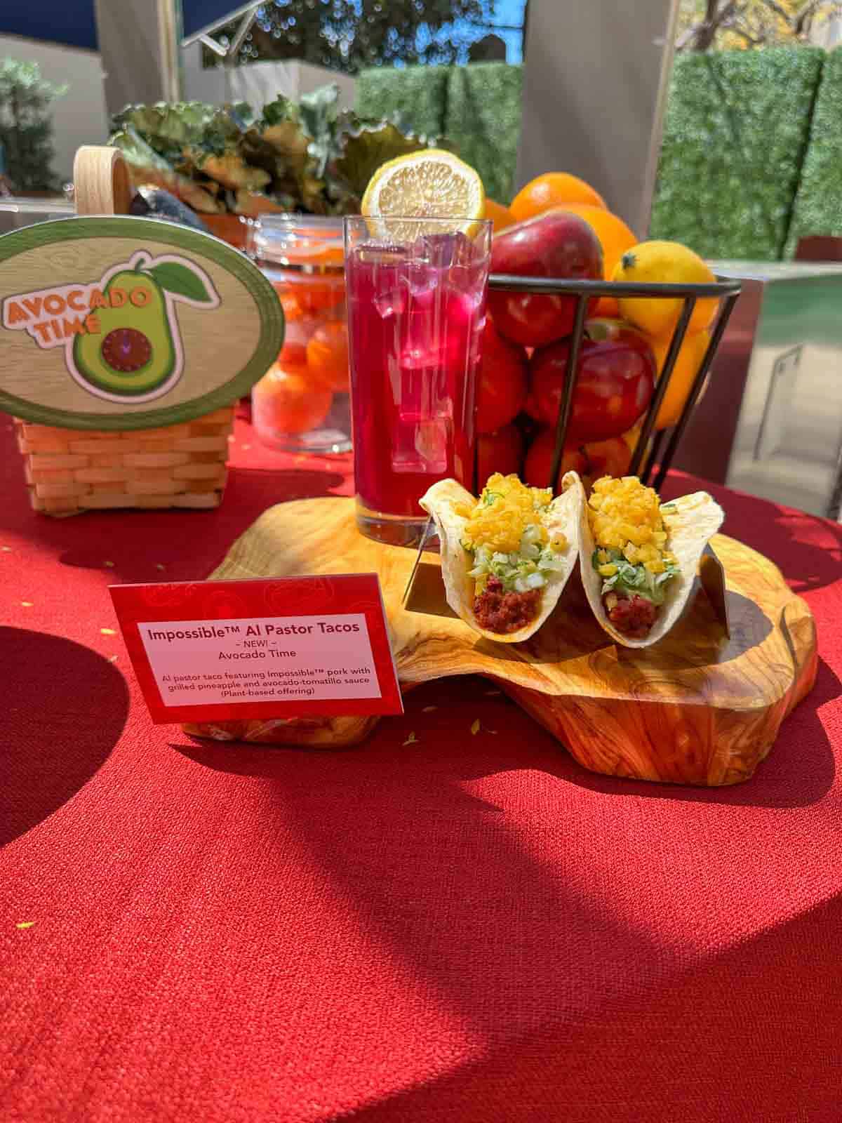 Two tacos on a wooden plank topped with lettuce and mango salsa.