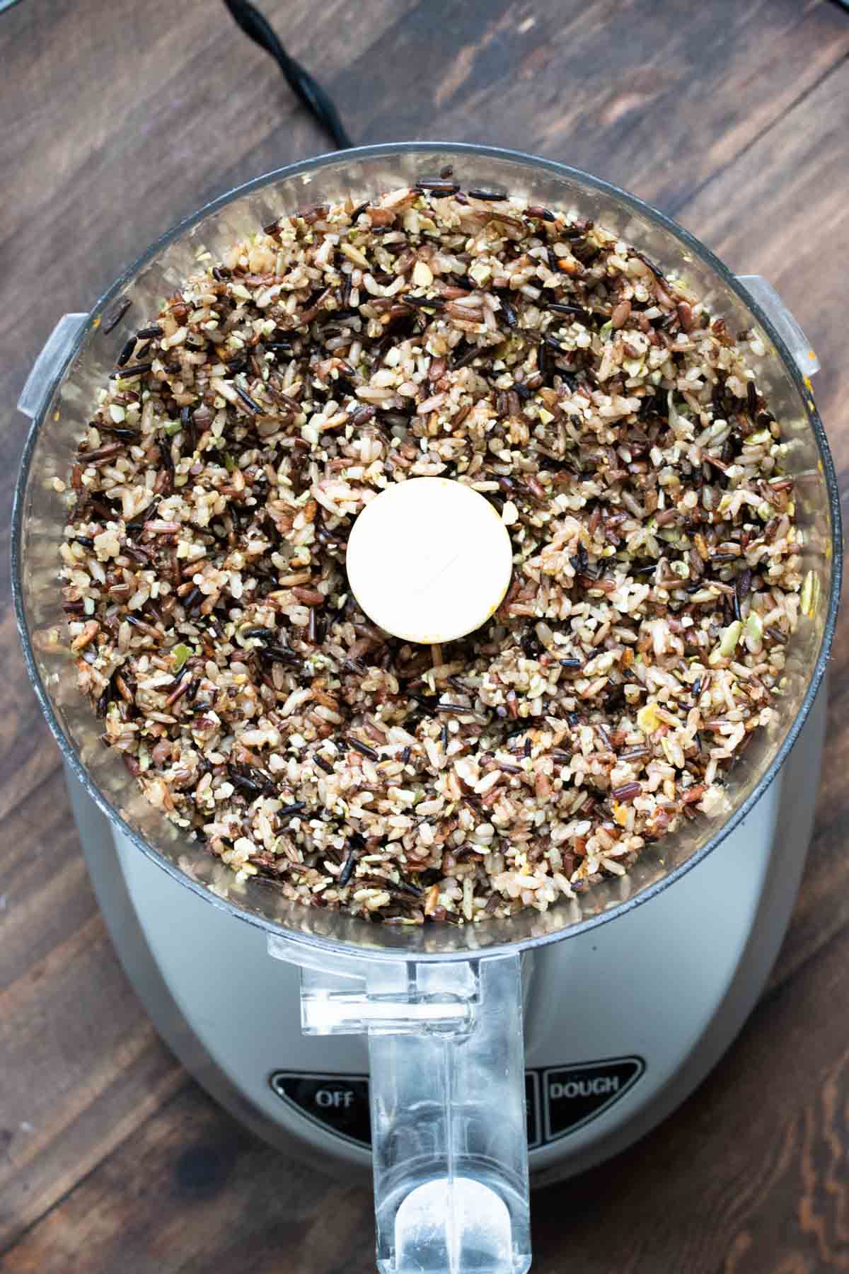Top view of a food processor with wild rice mixture in it.