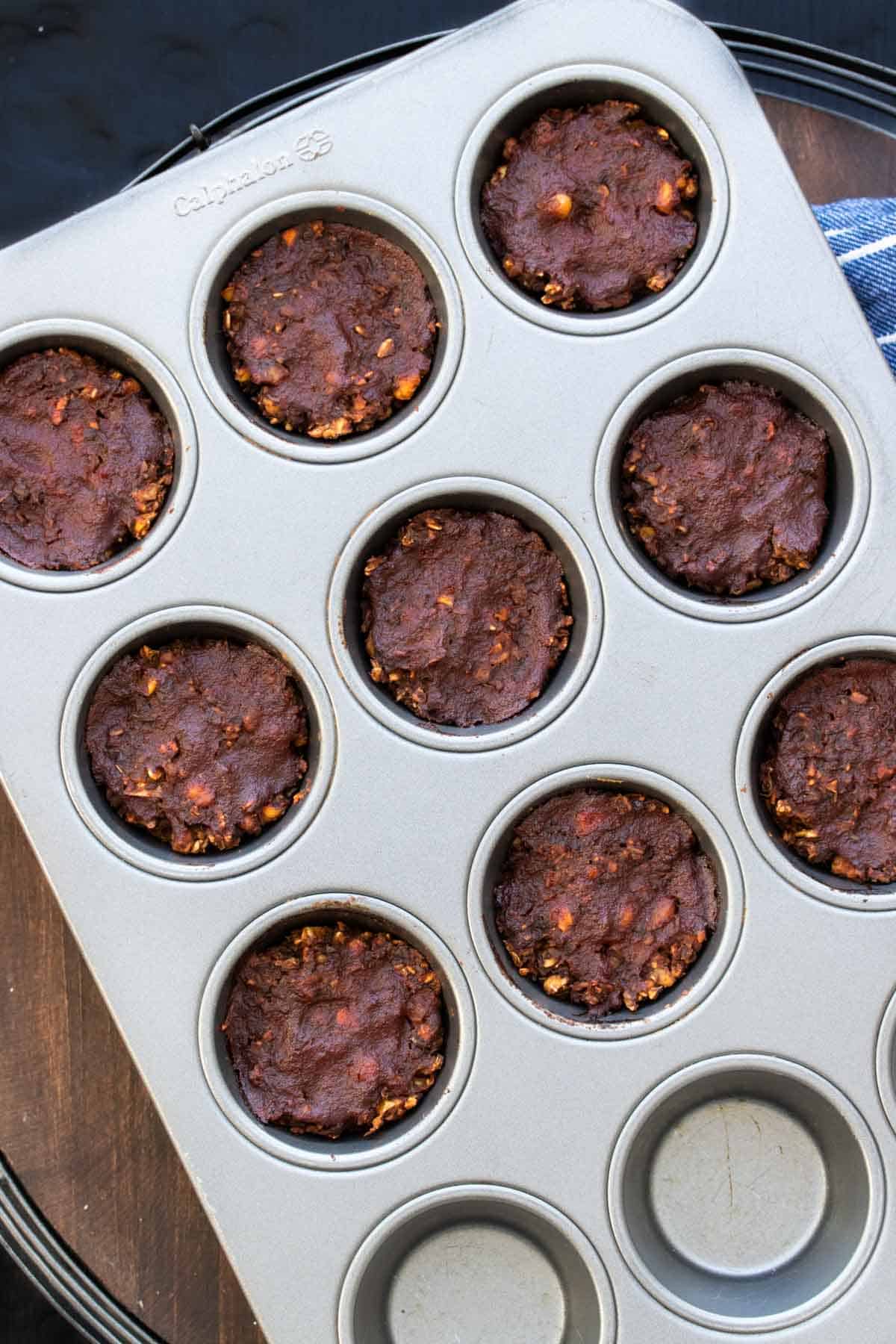 Vegan lentil meatloaf put into muffin tins and topped with barbecue sauce and baked.