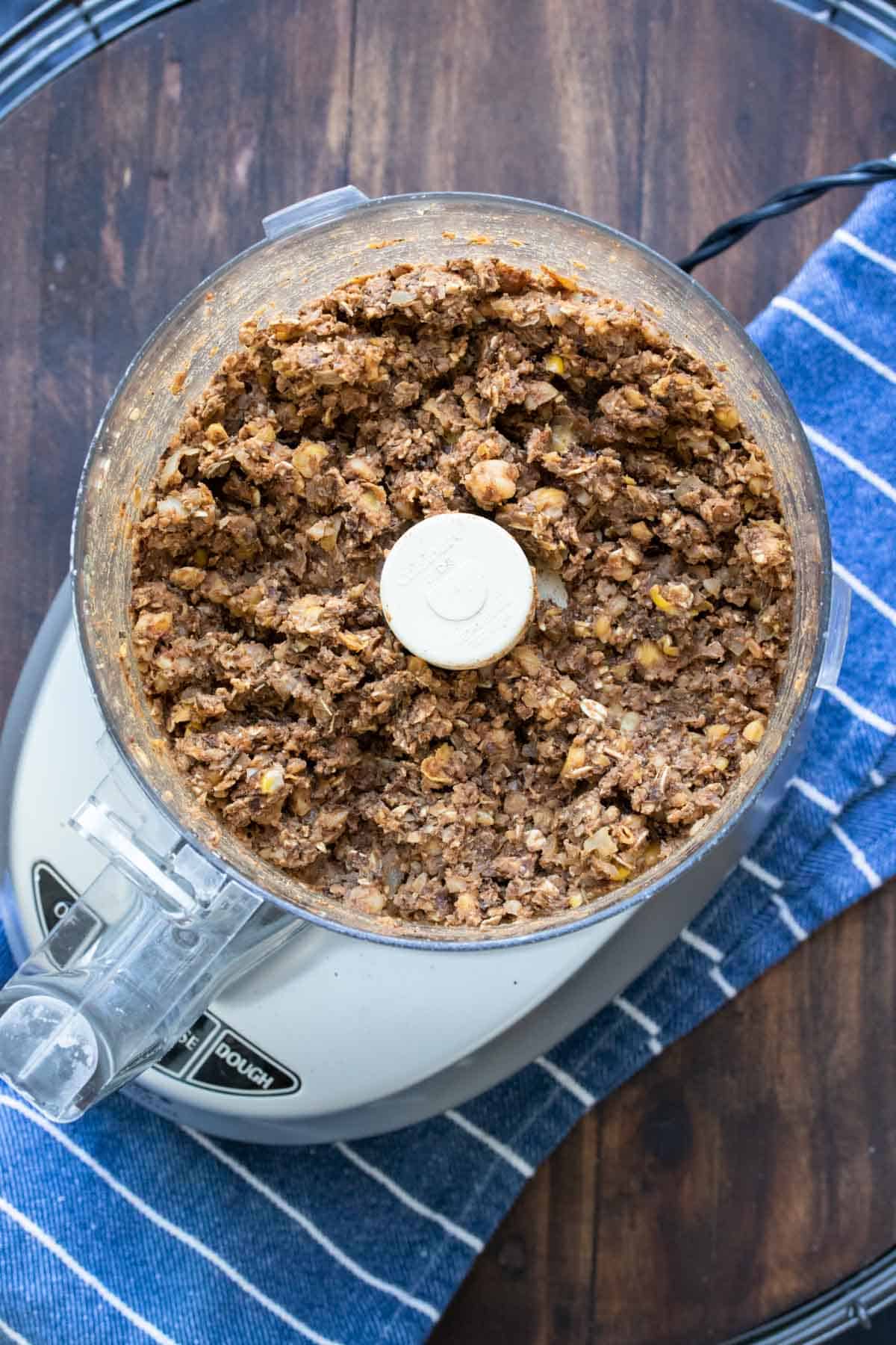 Top view of a food processor with lentil meatloaf mix inside.